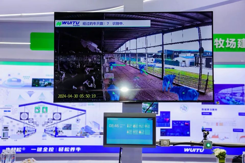 展台大屏实时演示 AI 视觉识别牛只,下方是“牛轻松®”中控屏
